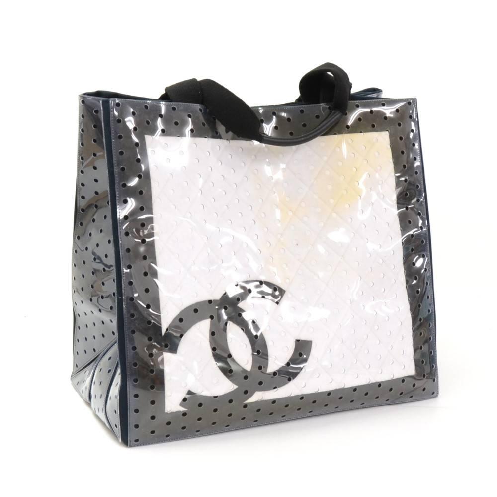Chanel hand bag in Black cotton x vinyl. Chanel CC logo is stitched on the front of the bag. The inside has 1 large pocket with zipper and 6 open pockets. Comfortably carried in hand and offers great capacity. Would make a perfect Beach bag due to