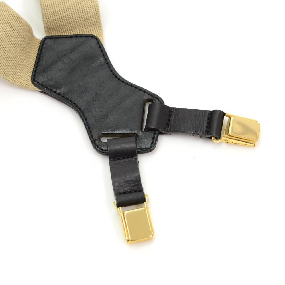 Chanel beige x gold tone suspenders. It has CHANEL printed in black on beige rubber. 6 gold tone clips to secure the suspenders on to your clothing. Very rare item!!Total length from one end to the other is app 32.3 inch or 82 cm (longest).

Made