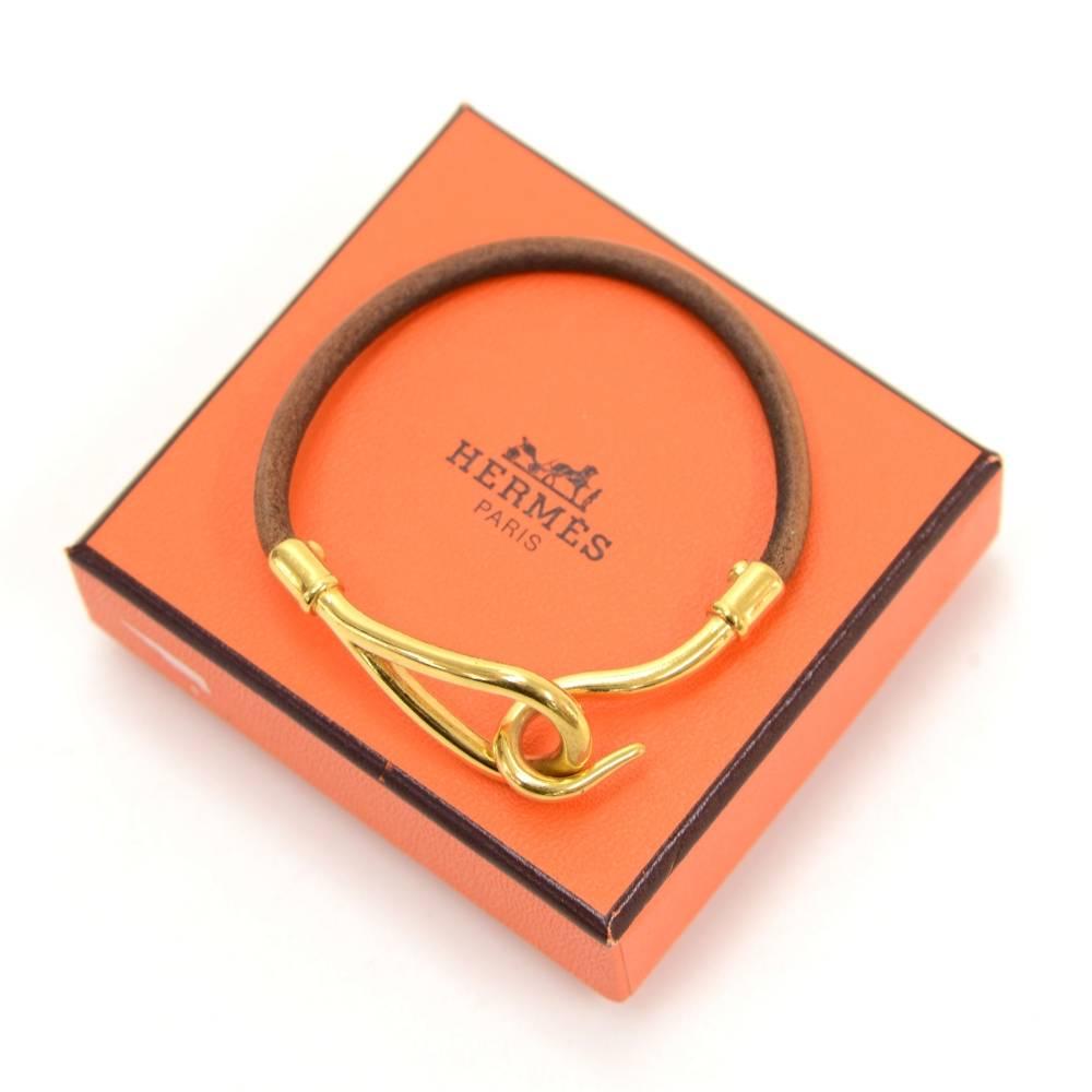 Hermes leather Jumbo bracelet. It has gold tone with simple hook style. Hermes is engraved on the hook. It looks very stylish and great statement. 

Size: 7.1 x 0.2 x x inches or 18 x 0.5 x x cm
Color: Brown
Dust bag:   Not included  
Box:  