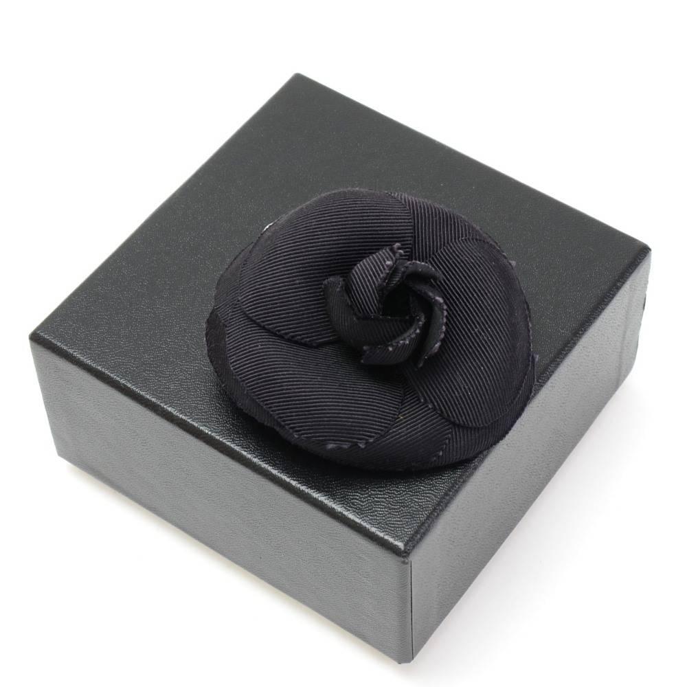 Chanel black camellia flower Brooch. It has a pin with secure closure. On the back is engraved Chanel CC Made in France. Can be attached to your Jacket or secure your scarf or used as accessory.

Made in: France
Size: 2.8 x 2.8 x 0 inches or 7 x