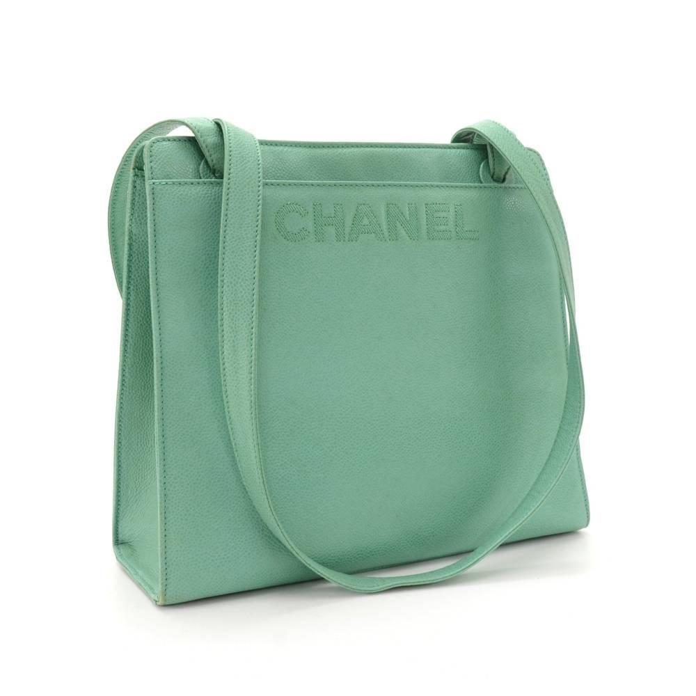 Chanel tote in light green caviar leather with large stitched CHANEL in front. It has 3 compartments: 2 open and the middle one secured with 2 magnetic closure. The middle one has 2 interior zipper pockets. Comfortably carried on shoulder and offers