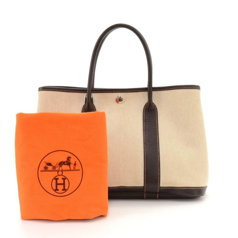 Hermes canvas and leather Garden Party TPM Bag. Famous bag secured with silver tone stud in the middle and there are stud on each side as well. Hand held with great capacity simply stunning. Inside as well as on the studs is engraved HERMES PARIS.