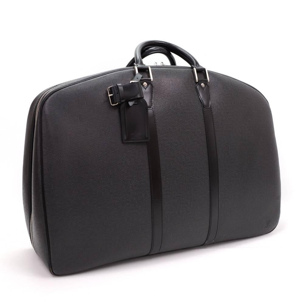 Louis Vuitton Helanga 1 Poche Garment travel bag in black taiga leather. It comes with comfortable rounded leather handles and full-length central zipper. Inside is in alkantra lining with 2 open pockets and garment for your suite. Comes with 1