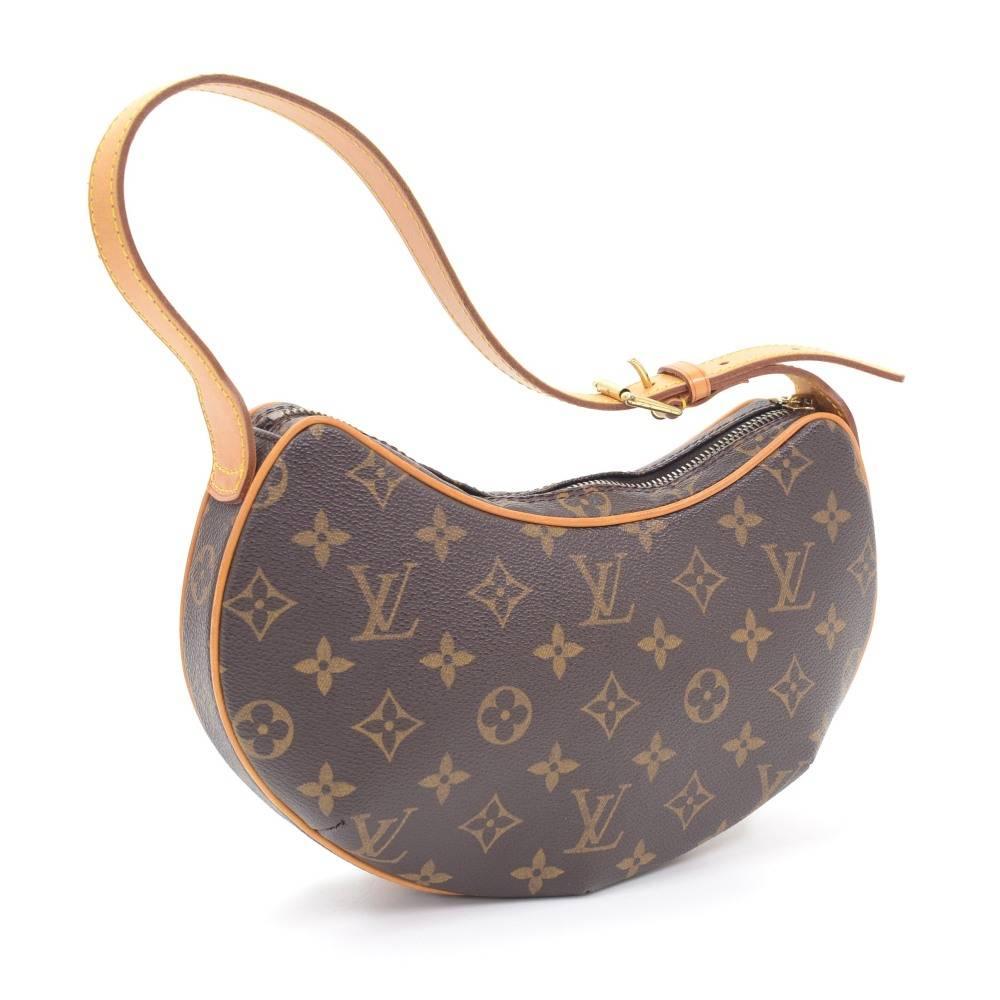 Louis Vuitton Pochette Croissant in monogram canvas. Top is secured with a zipper. Inside has red alkantra lining and 1 open pocket. Carried on one shoulder or in hand with adjustable cowhide leather strap.

Made in: France
Serial Number: