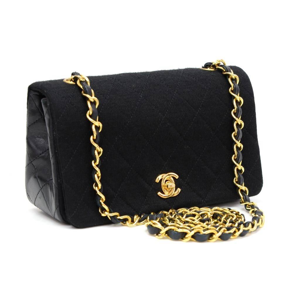 Chanel quilted mini shoulder bag in black quilted cotton x lambskin leather. It has a flap top with CC twist lock on the front. Inside has Chanel red leather lining and 1 open pocket splitted into 3 compartments. Comfortably carried on shoulder with