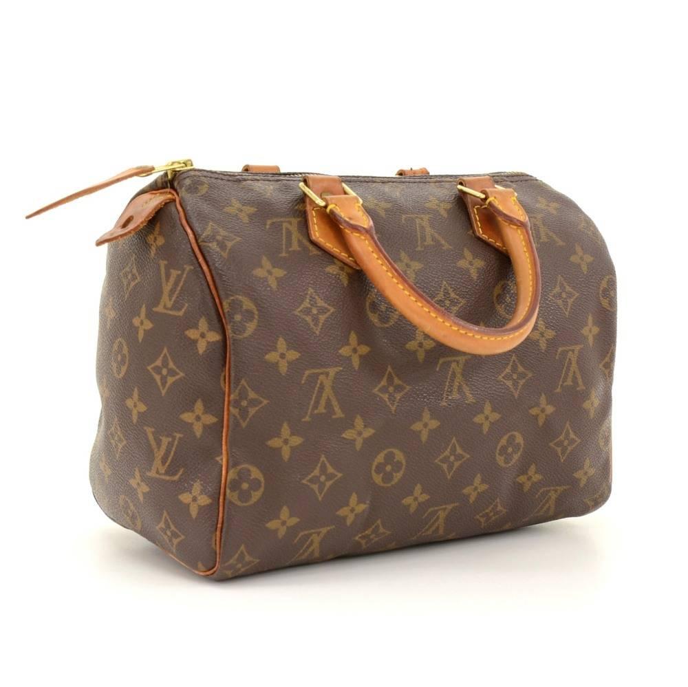 Hand-held Louis Vuitton Speedy 25 hand bag in Monogram Canvas. It offers light weight elegance in a compact format. Inspired by the famous keep all travel bag, it features a zip closure. This bag is perfect for carrying everyday essentials. One of