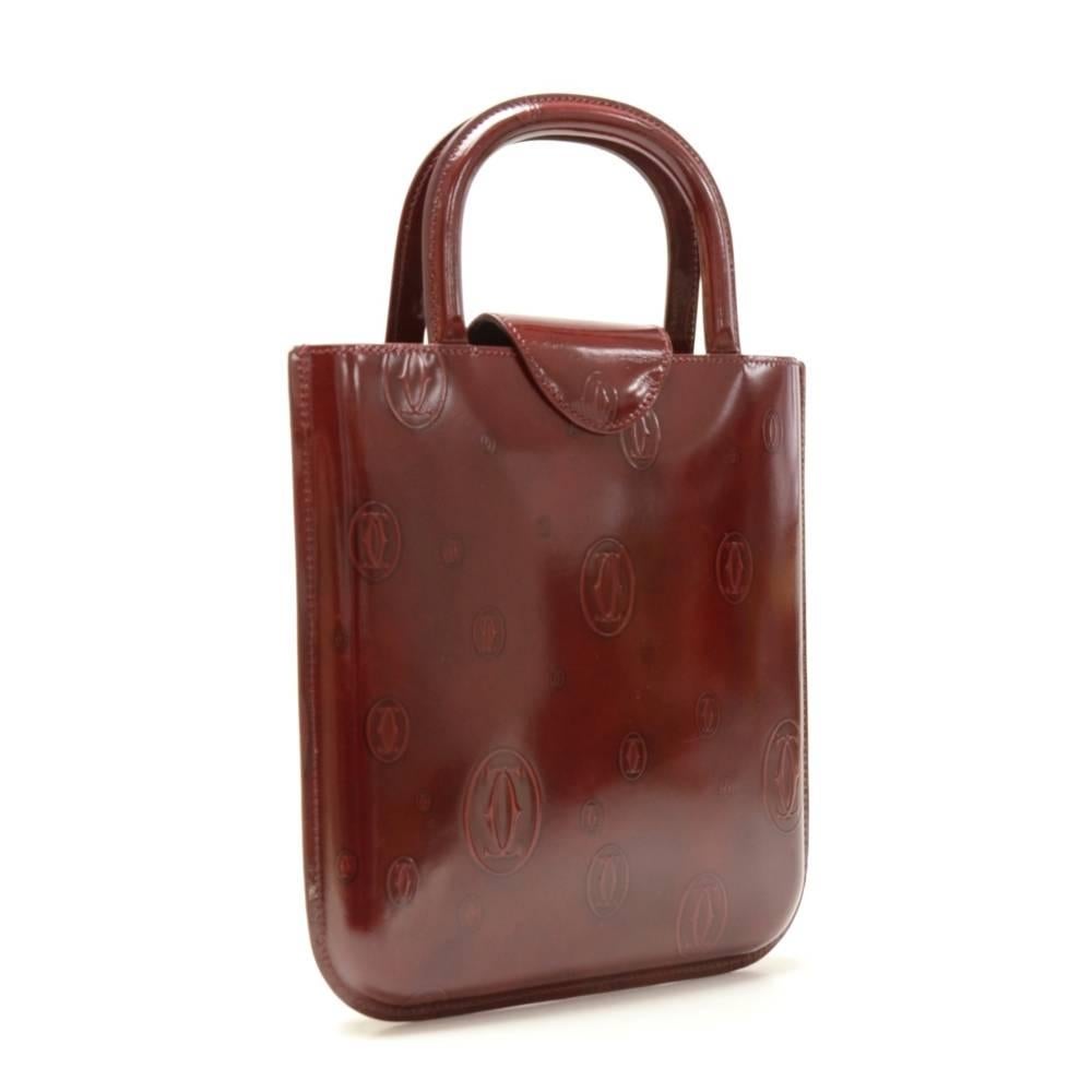 Cartier Happy Birthday hand bag in lovely burgundy patent leather. Top is secured with small flap and magnetic lock. A great companion wherever you go. Fits nicely iPad and similar tablet.  

Made in: France
Serial Number: ELFH
Size: 8.3 x 9.1 x 0