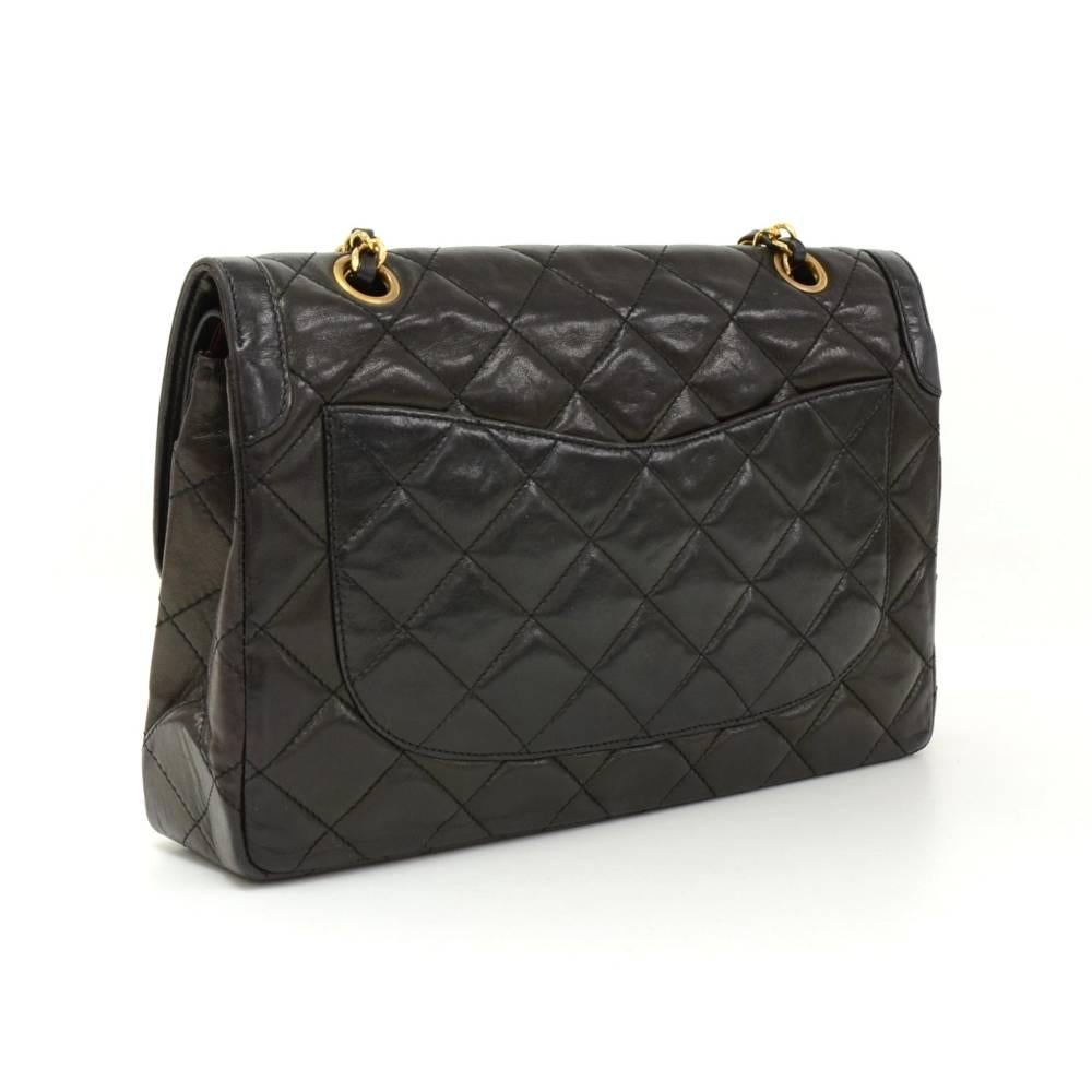 Vintage Chanel black quilted leather bag with double flap. It has CC twist lock in silver x gold tone on the front flap. Second flap has stud closure. Underneath it, there is one slip in pocket and inside lining is in famous Chanel red leather. One