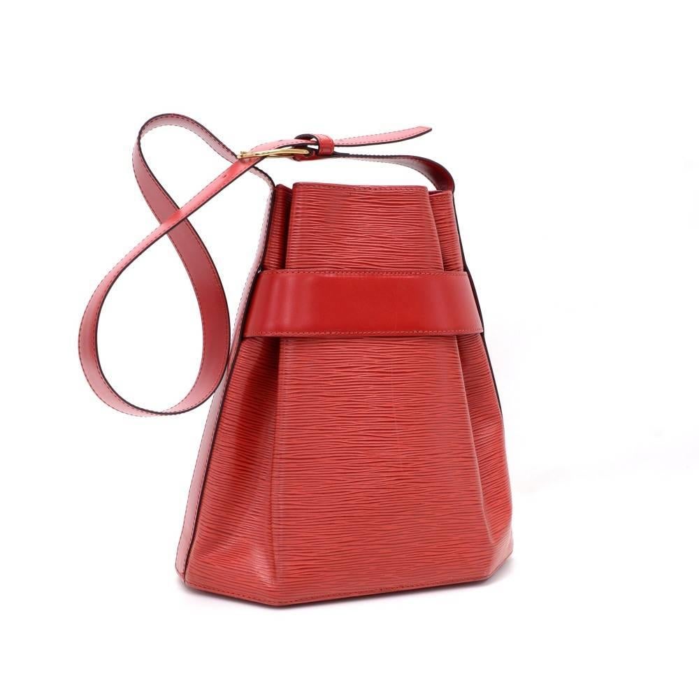 Louis Vuitton Red Sac D'epaule Epi leather shoulder bag. It has open access with a leather strap around the top of the bag secured with a stud. It is carried on the shoulder with its adjustable shoulder strap. Inside has alkantra lining with a