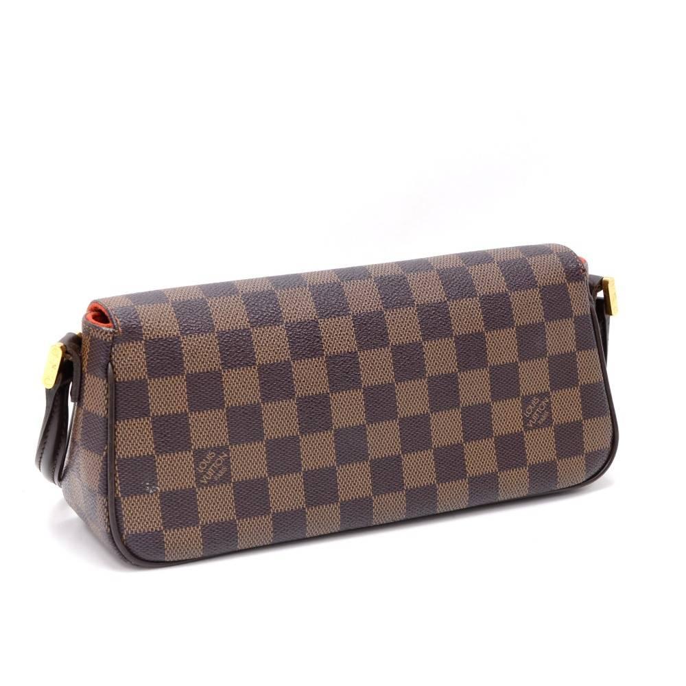 Louis Vuitton  hand bag in brown Damier canvas. It has flap with magnetic closure. Inside has red alkantra lining with 1 open pocket. It stores beauty products and other daily essentials. Stay organized in style!

Made in: France
Serial Number: F L
