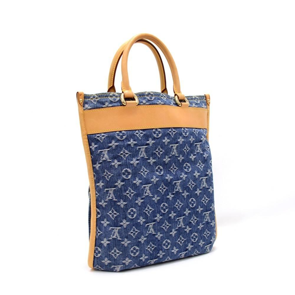 Louis Vuitton Flat Shopper tote/handbag in Denim Monogram. Outside, it has 1 zipper pocket and 1 small pocket with flap and lock closure on front. Open access. Inside is in yellow alkantra lining with 1 open pocket. Comfortably carried in hand with