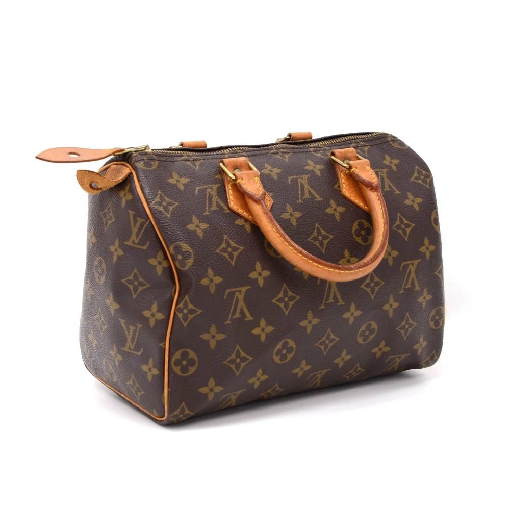 Hand-held Louis Vuitton Speedy 25 hand bag in Monogram Canvas. It offers light weight elegance in a compact format. Inspired by the famous keep all travel bag, it features a zip closure. This bag is perfect for carrying everyday essentials. One of