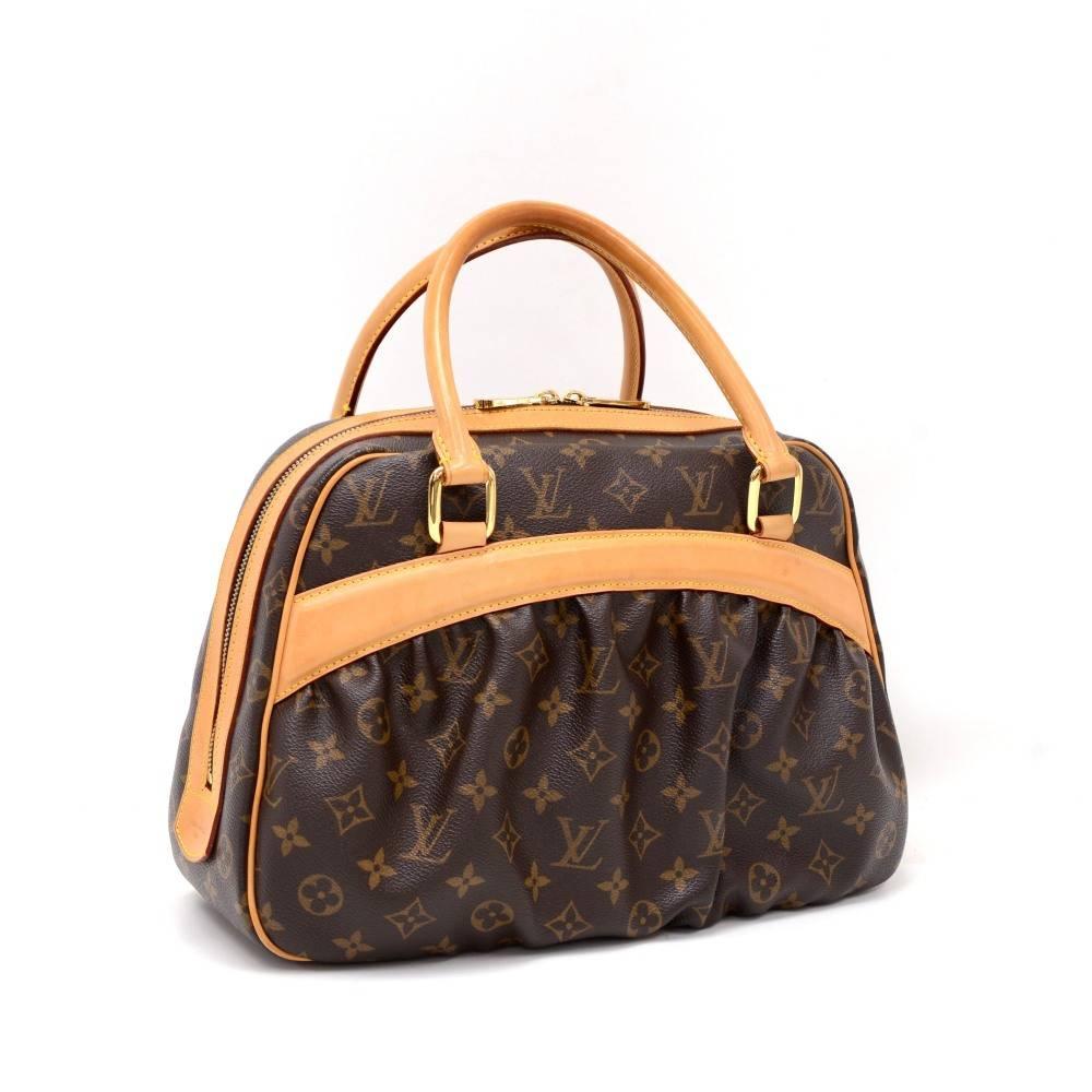 Louis Vuitton Mizi bag in monogram canvas. It has 1 open slip pocket on front. Top closed with double zipper. Inside has red alkantra lining with 1 open pocket and 1 for mobile. Discontinued item to find. 

Made in: Spain
Serial Number: C A 1 0 1