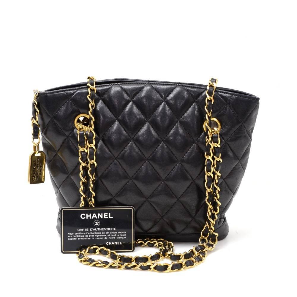 Vintage Chanel shoulder bag in black quilted leather. It has zipper on top with attached charm as zipper pull. Inside has matching leather with 1 zipper pocket. Carry on shoulder with double chain.

Made in: Italy
Serial Number: 1161446
Size: 8.3 x