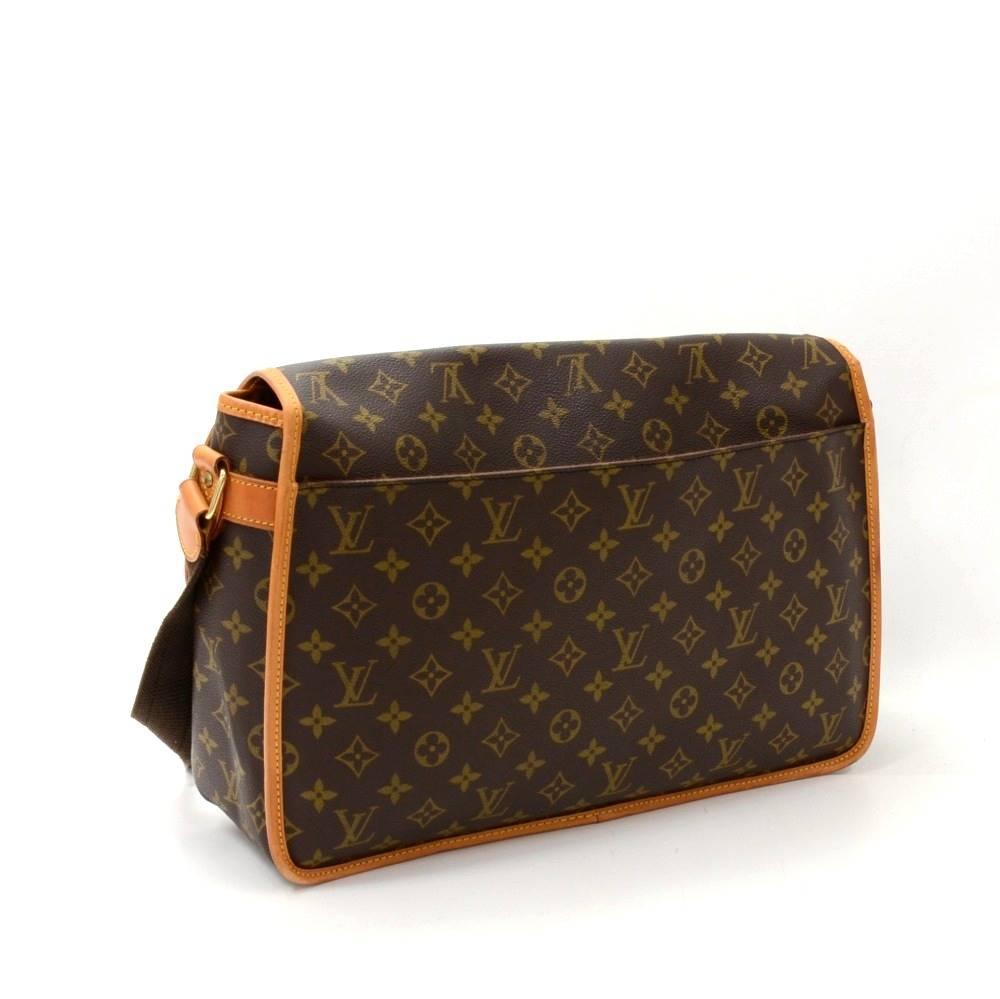 Louis Vuitton Sac Gibeciere GM messenger bag in monogram Canvas. It has flap with belt closure on front and 1 open slip pocket on back. Underbeneath the flap, it has 2 exterior open pockets. Inside has  1 zipper pocket with great capacity. Very