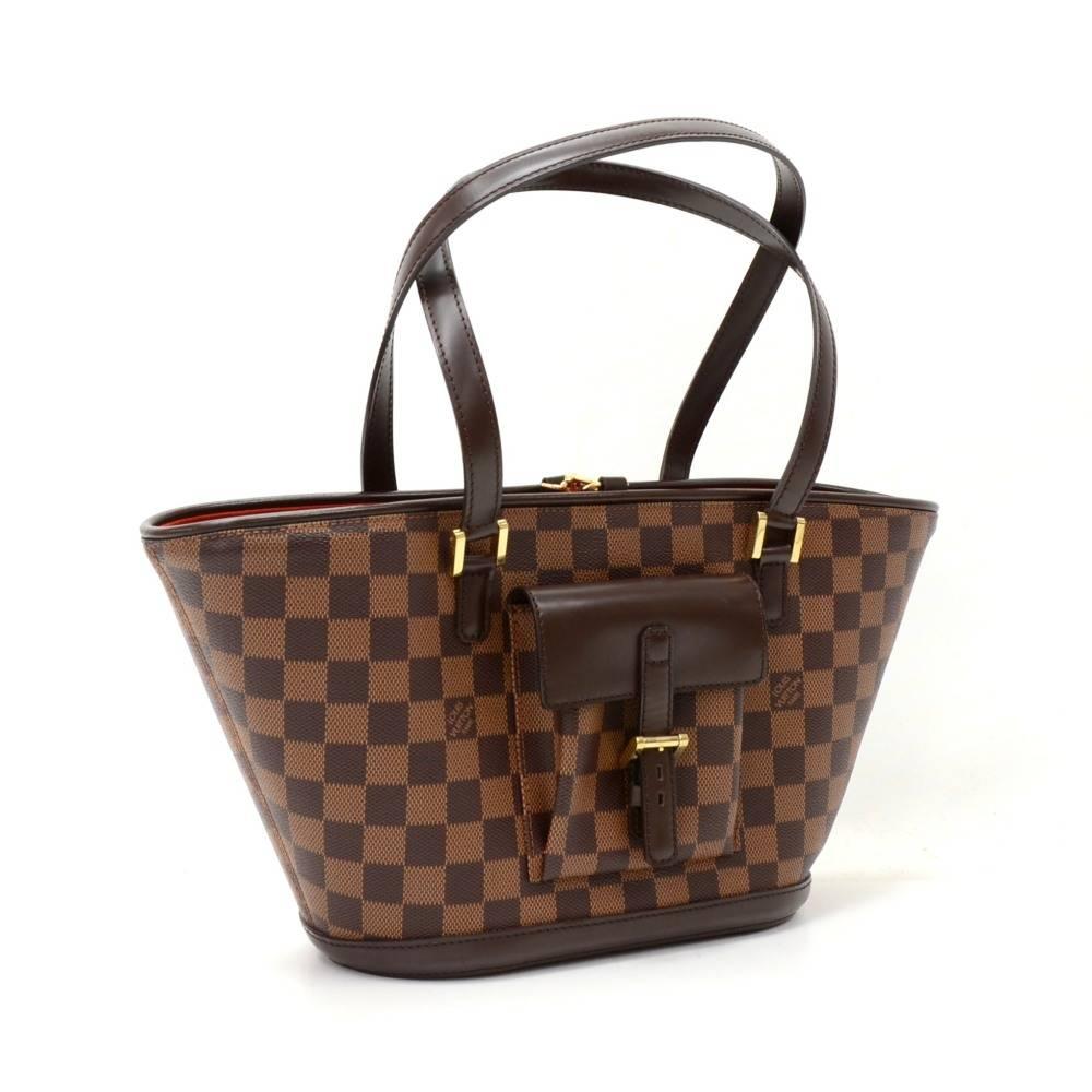 Louis Vuitton Manosque PM tote bag in damier canvas. Outside, has small flap pocket with leather belt closure. Top access is open with hook closure. Inside is in red alkantra lining with 2 zipper pockets. Perfect to carry all your daily necessities.
