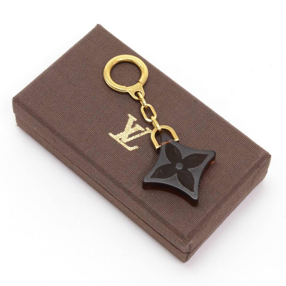 Louis Vuitton brown Key holder.Discontinued model. Brass chain with plastic flover LV singature design. 

Made in: France
Size: 3.7 x 1.6 x 0 inches or 9.5 x 4 x 0 cm
Color: Brown
Dust bag:   Not included  
Box:   Yes included 

Condition
Overall: 9