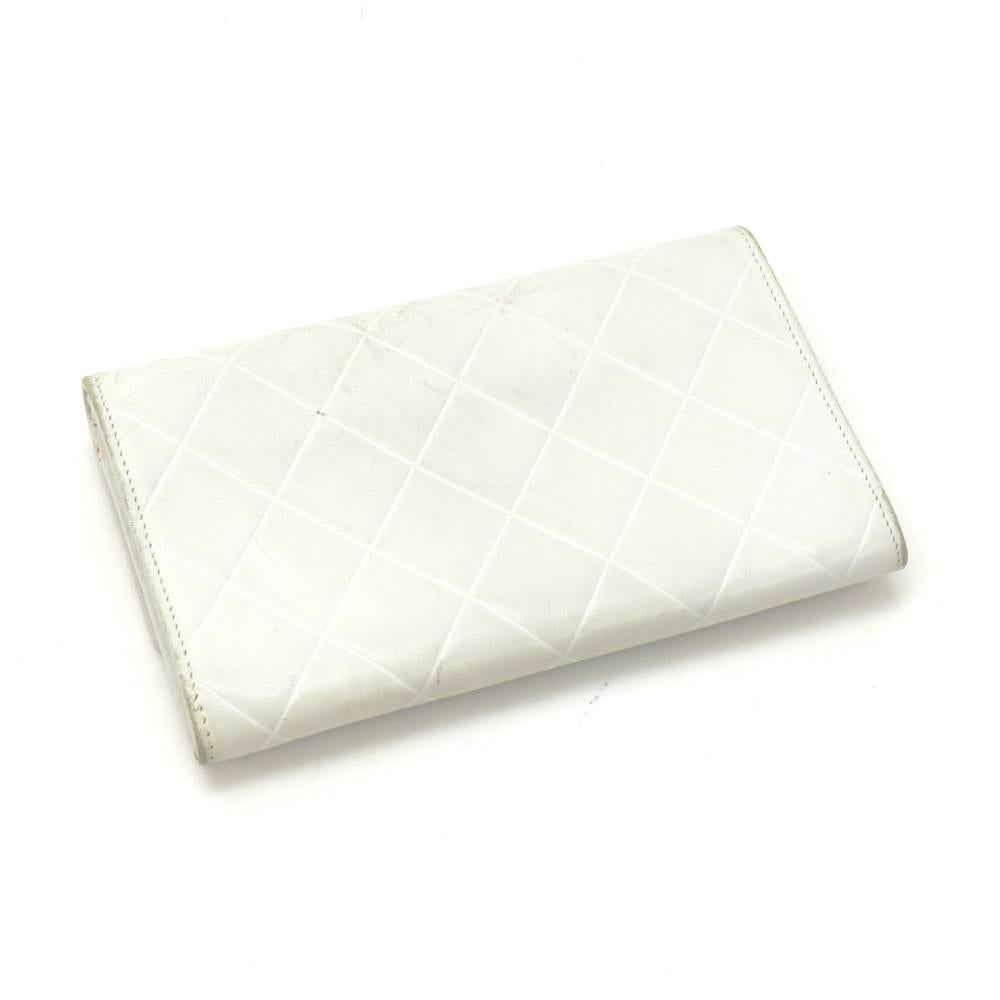 Chanel white leather bifold wallet. It has stamped CHANEL on flap and fron stud closure. Inside has 1 exterior open pocket, 1 compartment for coin with zipper closure, 1 note compartment, and 3 card holders. Very cute!

Made in: Italy
Serial Number: