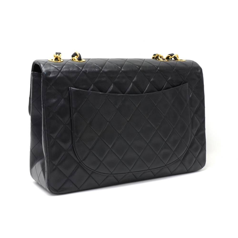 Chanel Maxi Jumbo in black quilted leather. It has flap top with famous large CC twist lock on the front. Outside on the back has 1 open side pocket. Inside has Chanel red leather lining and 2 pockets: 1 zipper and one open. Comfortably carried on