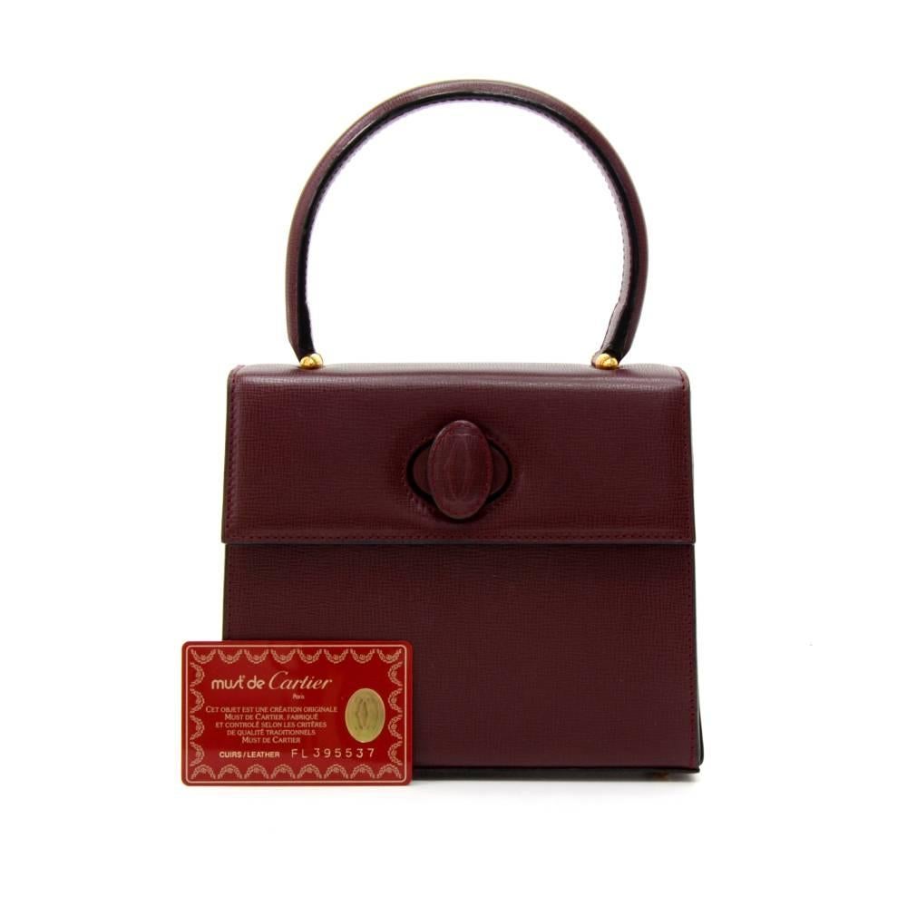 Vintage Cartier burgundy cowhide leather handbag of the Must de Cartier line. It has twist lock on the front flap. Inside lining is in burgundy fabric with Cartier monogram with 1 zipper pocket. A very rare find. SKU: KA035

Made in: France
Serial