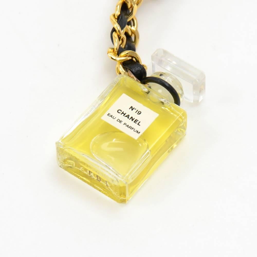 Chanel necklace featuring a cute classic N°19 Chanel perfume bottle pendant. The chain is the famous leather and gold brass interwoven chain. The actual perfume liquid is not included.Size: Chain drop is app 11.4 inches or 31 cm, pendant is app