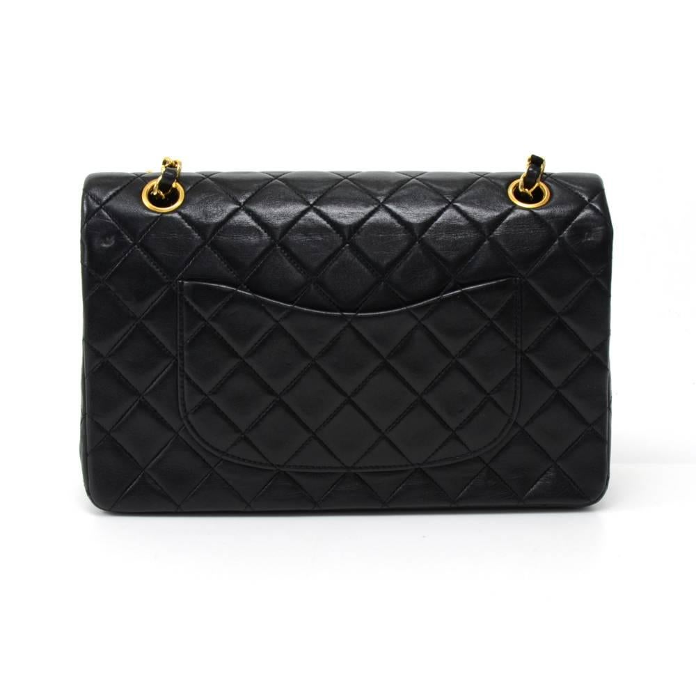  Vintage Chanel black quilted leather bag with double flap. It has CC twist lock on the front flap. Second flap has stud closure. Underneath it, there is one slip in pocket and inside lining is in famous Chanel red leather. One interior open pocket