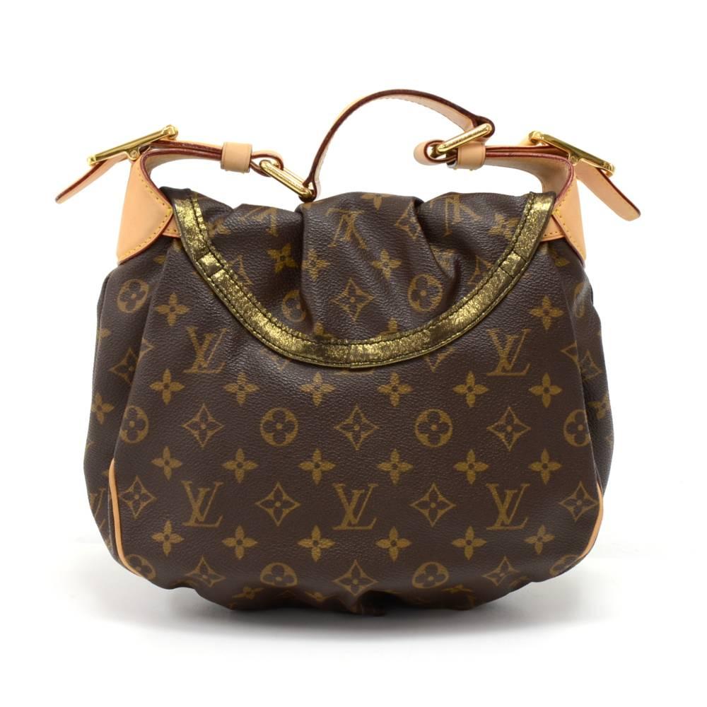 Authentic Louis Vuitton Kalahari PM handbag in Monogram Canvas. It has a flap closure with resin and metallic charms on front. Inside is lined with gold metallic fabric under the flap and dark brown alkantra lining with 1 open pocket and 1 pocket