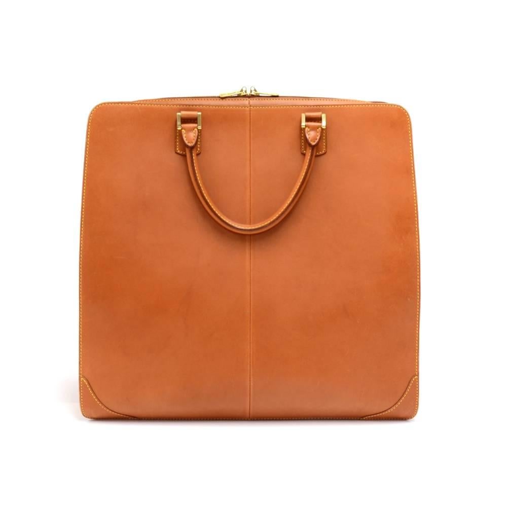 Louis Vuitton Negev GM travel tote bag in caramel brown nomade leather.  Outside has one open pocket secured with two push buttons,  and the main access is secured with a double zipper. The inside is lined with red alkantra and has two open pockets