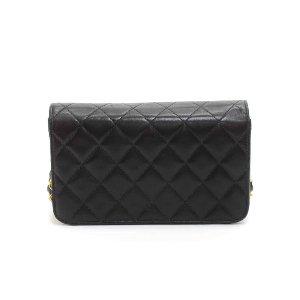 Vintage Chanel quilted mini shoulder bag in black quilted leather. It has a flap top with CC stud closure on the front. Inside has Chanel red leather lining and 1 open pocket. Comfortably carried on shoulder with single chain or as a clutch. A