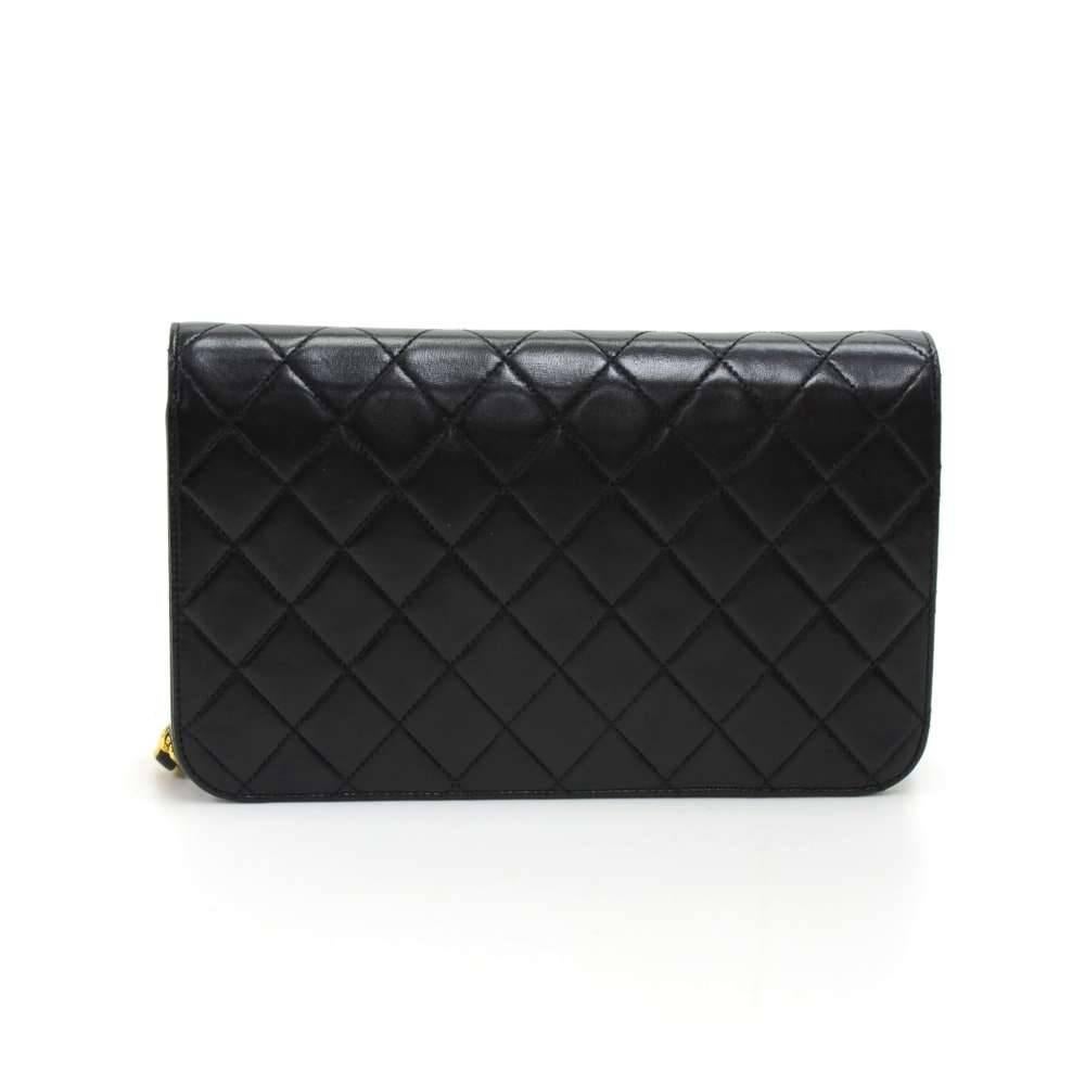 Chanel Black leather quilted shoulder bag. It has a single flap with a stud closure on the front. Inside has Chanel red leather lining with 1 zipper pocket. Can be carried as a clutch or on the shoulder with the classic chain and leather entwined