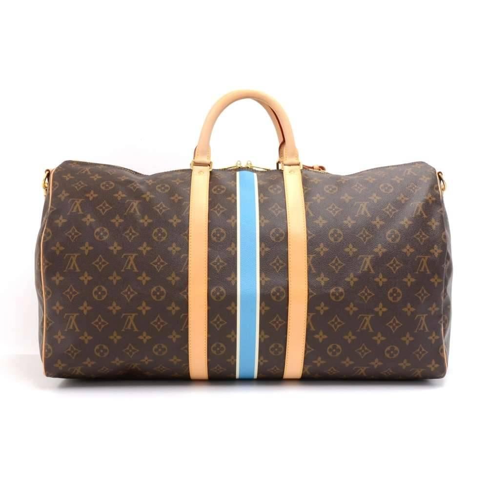 Louis Vuitton Keepall Bandouliere 55 in Mon Monogram Canvas. This bag has 3 Vertical  Stripes in colors Blanc and Bleu Claire. It has a monogram canvas with cowhide leather trim and rounded handles. It has a double zipper closure with gold-tone