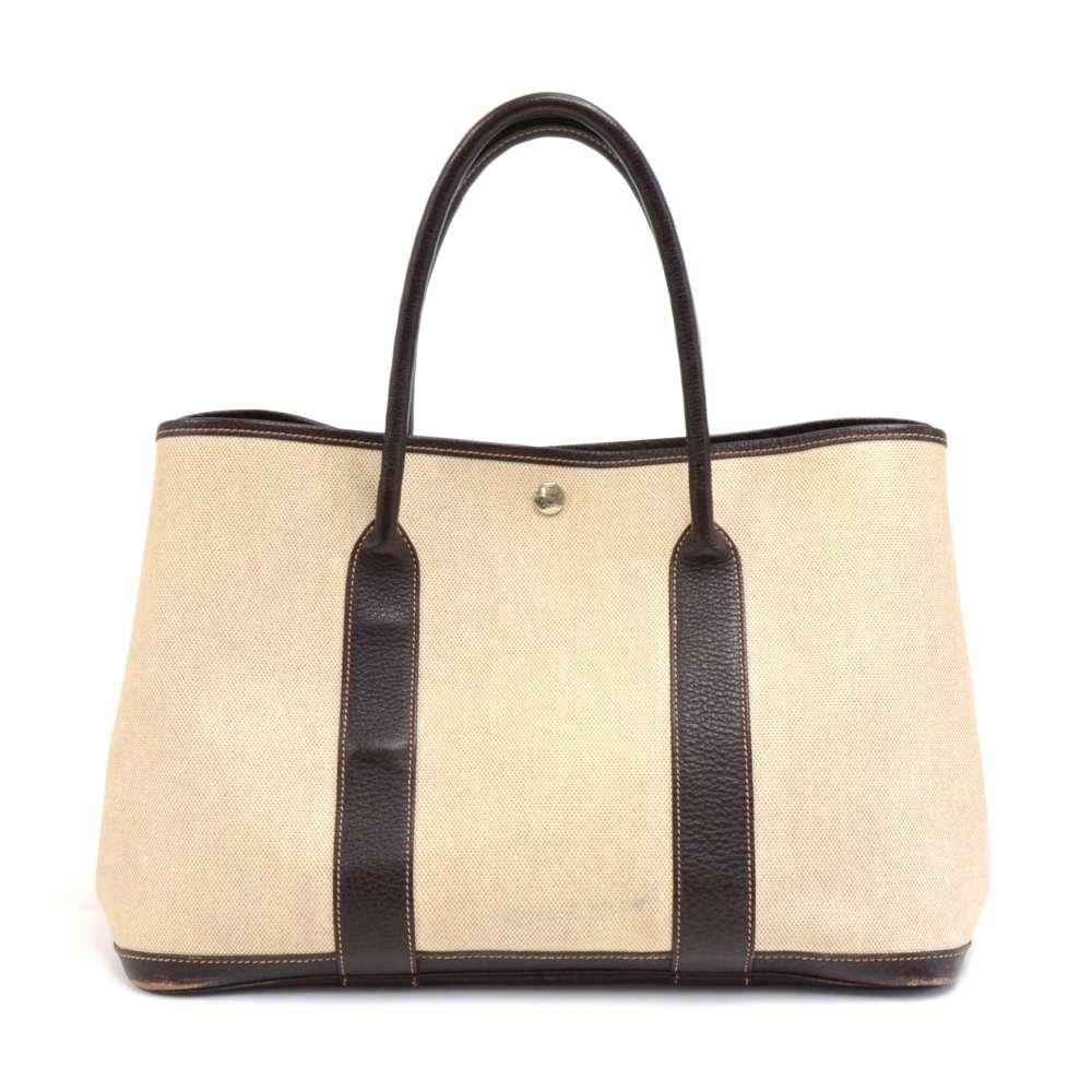 Hermes canvas and leather Garden Party PM Bag. Famous bag secured with silver-tone stud in the middle and there are stud on each side as well. Hand held with great capacity simply stunning. HERMES PARIS is engraved on all the studs. SKU: HA888

Made