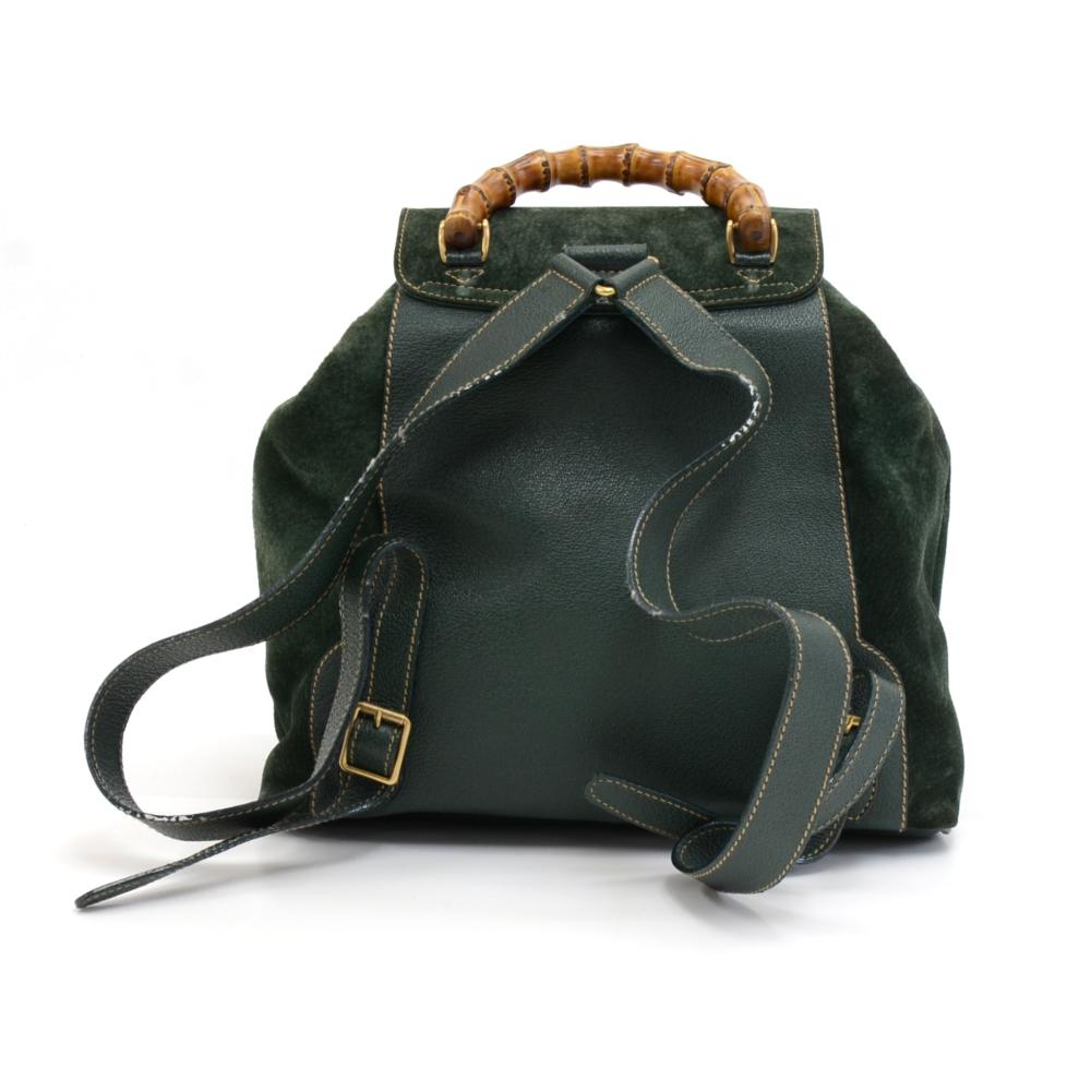 Vintage Gucci bamboo backpack in green leather and suede leather.  The front has two large pockets with a bamboo twist locks. The main access is secured with a belted top flap with a bamboo detail on the buckle. Underneath the flap, there is a draw