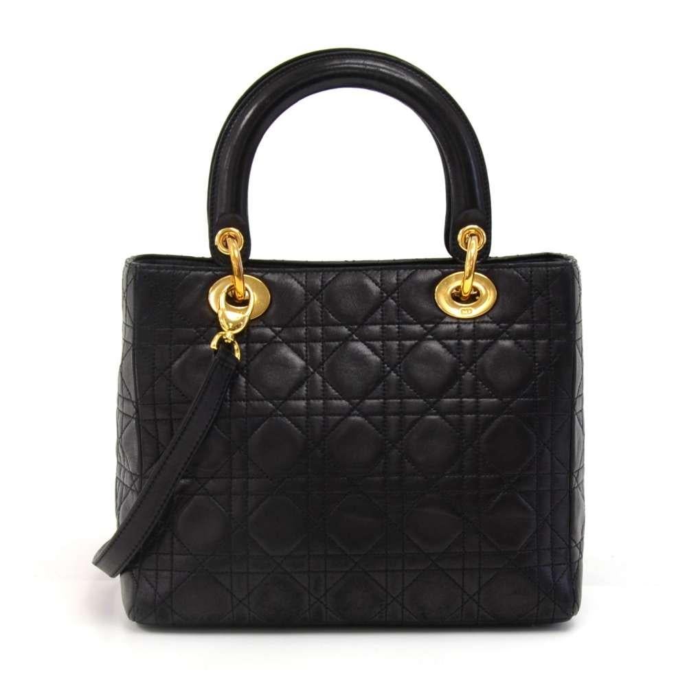 Christian Dior Lady Dior hand bag in Black cannage quilted lambskin leather. It has lovely light gold details including the bag charms spelling out 
