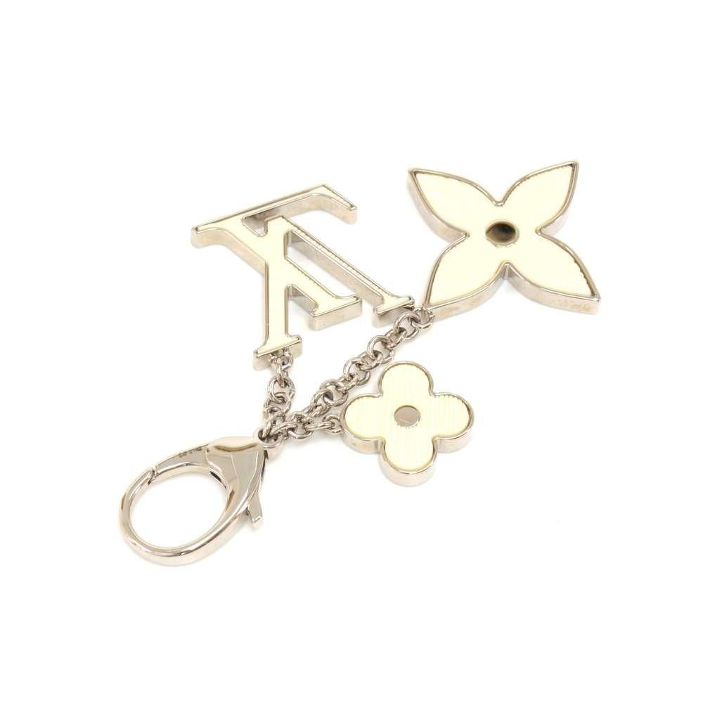 Authentic Louis Vuitton Key holder/Bag charm. White charms in the shape of the classic Louis Vuitton Monogram flowers and logo. Rare design would make your keys easy to find. Would also look great hanging from your bag! SKU: LQ201

Made in: