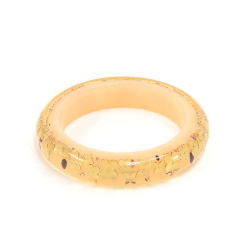 Louis Vuitton inclusion bangle / bracelet in beige resin. This bangle has the iconic Louis Vuitton monogram flowers in gold with pink and red rhinestones details. Very cute and lovely item to accessorize your look! Wearable diameter approx: 2.5 in