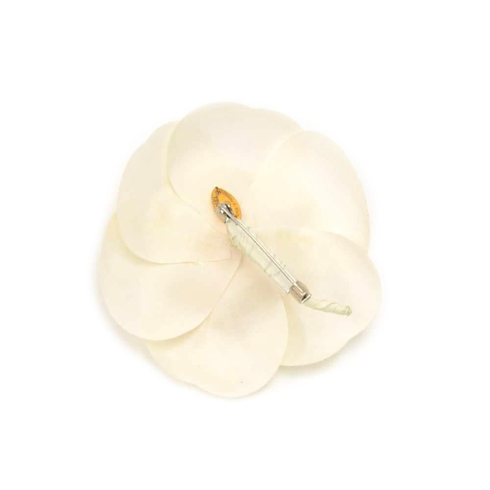 Chanel white camellia flower Brooch in white canvas. It has a pin with secure closure. 