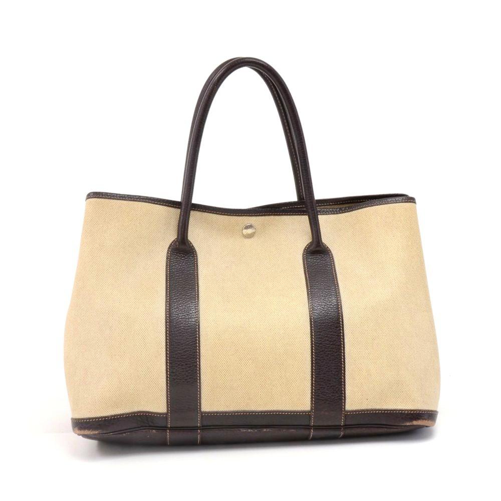 Hermes canvas and leather Garden Party PM Bag. Famous bag secured with silver tone stud in the middle and there are stud on each side as well. Hand held with great capacity simply stunning. HERMES PARIS is engraved on all the studs. SKU: 