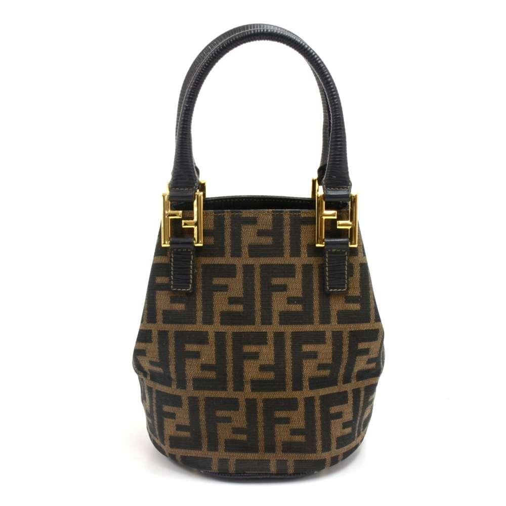 Fendi Tobacco Zucca Mini Bucket Bag. Most likely from the 1970s-80s. Has the classic monogram tobacco Zucca coated canvas with black leather and gold-tone hardware details.  The handle has gold-tone double F hardware and the bottom has brass feet to