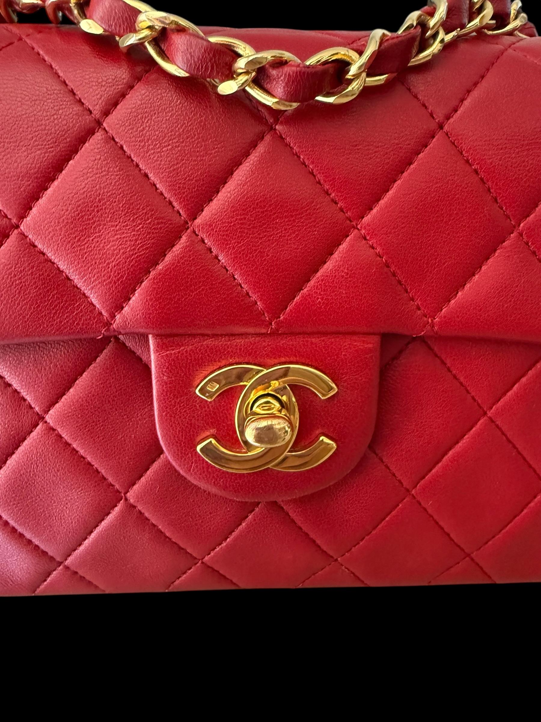 Rarement trouvé dans la Série 1 de Chanel, ce sac à rabat classique des années 1980 est réalisé en cuir d'agneau rouge vif, avec le matelassage en diamant caractéristique et des accessoires plaqués or 24 carats. La chaîne en cuir entrelacé et la