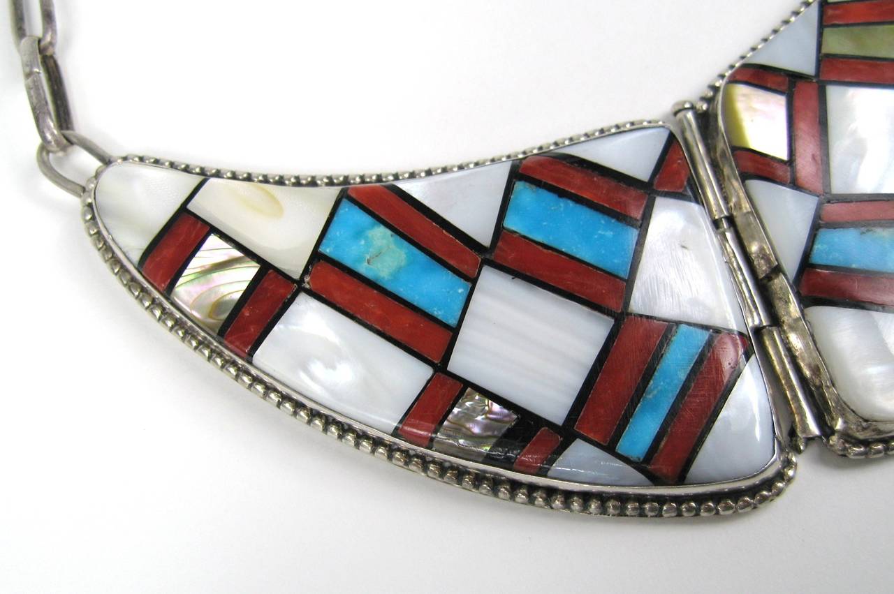 This massive Zuni Necklace made up of Coral,Turquoise, Spiny Oyster and Mother of pearl is stunning in person. Quite the statement piece.
Hand scrip signature 
3 panels 
Large links 
Hook closure 
Measuring 2.11