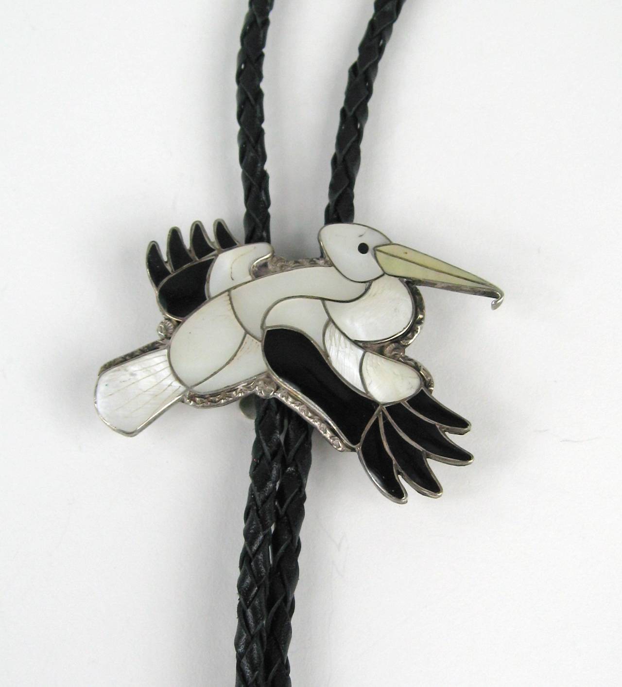 This is a fantastic vintage Native American handmade Bolor featuring a wonderful Bird. The inlay work is amazing!
artists Porfilio and Ann Sheyka. Porfilio and Anne are known for their animal designs and this is among the best. The detail that they