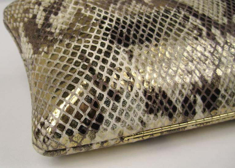 Very unique Judith Lieber design, beautiful hard rectangular case, magnificently trimmed in Gold tone at the top . All this glitz surrounds the twin panels of Python excellence that Lieber thoughtfully blended together.

Hard case is pillbox feel
