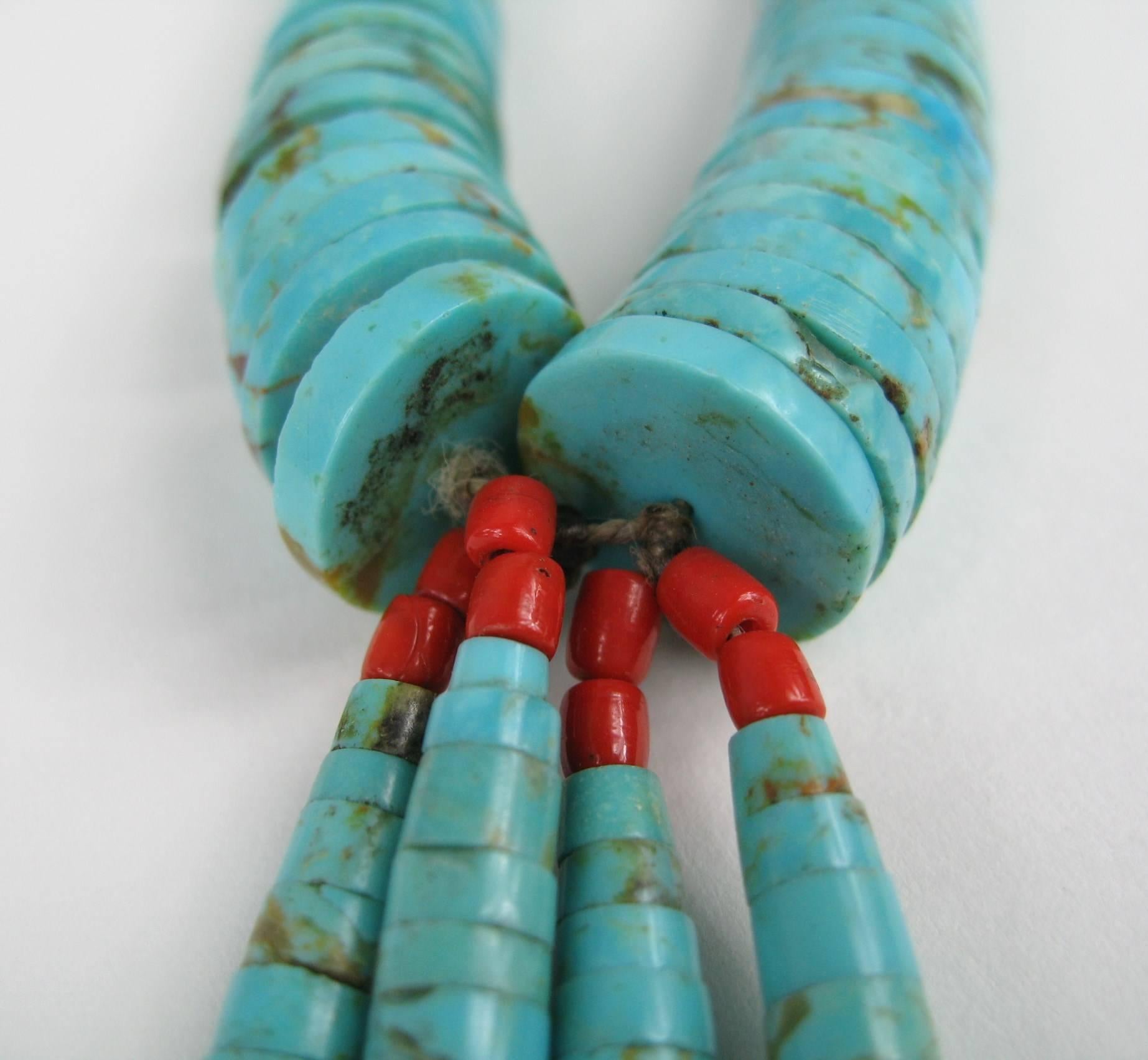 Graduated turquoise heishi necklace
attached jaclas 
carved clam shell centers
sterling silver findings and coral beads at the terminals with sterling silver hook
and eye closures
The entire piece is strung on the original string
Beads