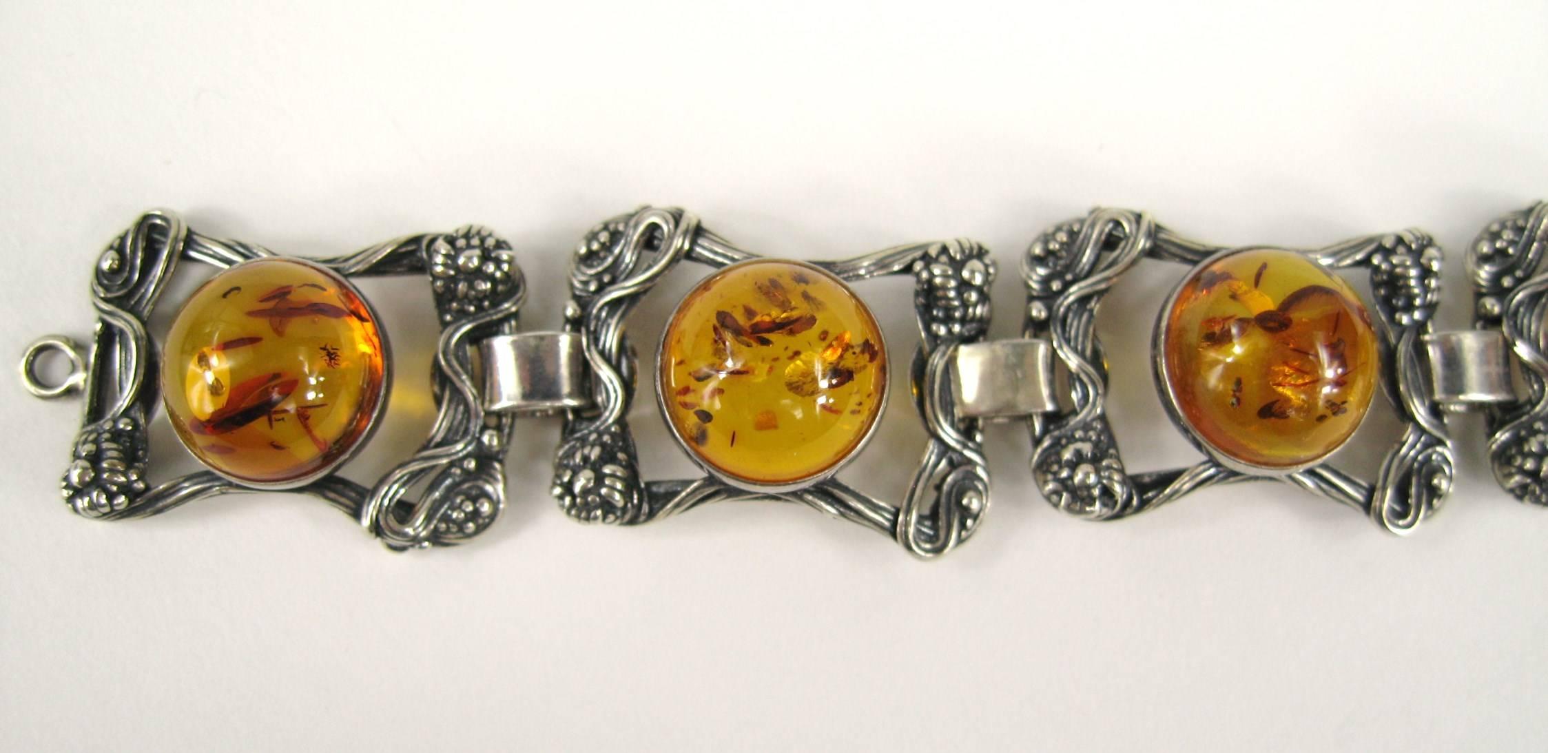 Sterling silver Bracelet set with bezel Amber 
Art Nouveau detailing 
6 Links 
Measuring 
.97