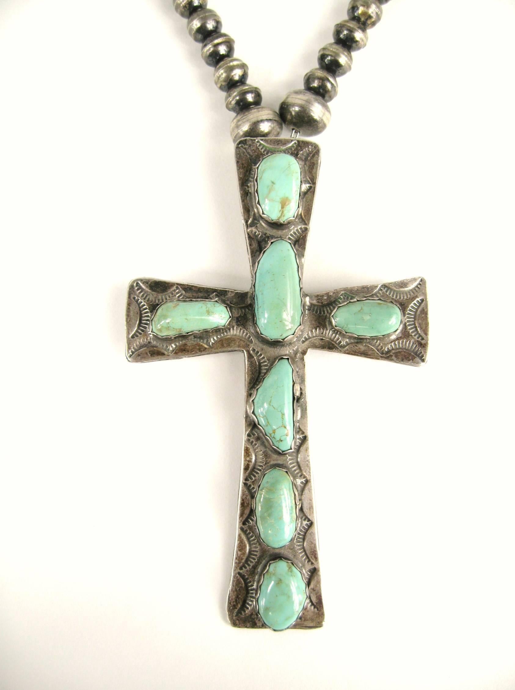 This is a massive hand crafted early Native American Navajo Cross. 7 large Turquoise stones set in this highly decorated cross. 
The cross measures 
4