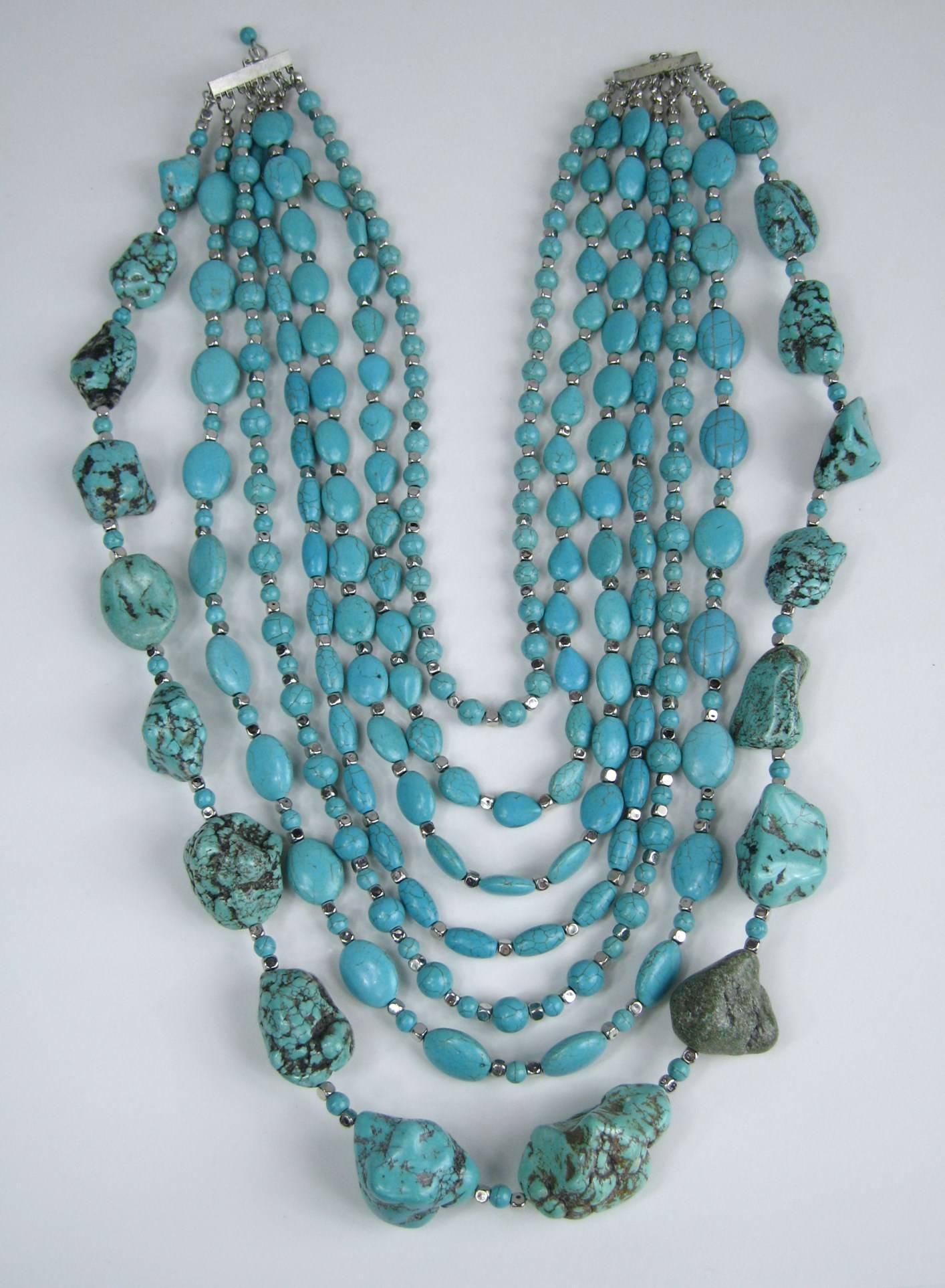 This is a statement piece, for sure! Large chunks of Turquoise on the bottom, with an additional 6 strands of smaller pieces of Turquoise. 
They range in size from 30.24mm x45 mm down to 7.9 mm x 7.3 mm 
You have round, oval and larges chunks of