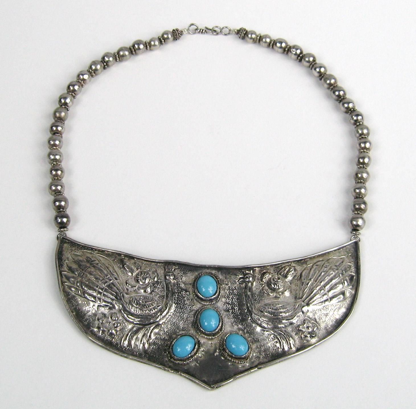 Turchese martellato al centro di questo splendido scudo in argento sterling. Misura 5,5 pollici di larghezza x 2,30 H. x 18,5 pollici dall'inizio alla fine delle perline. Questo fa parte di un'enorme collezione che comprende centinaia di gioielli