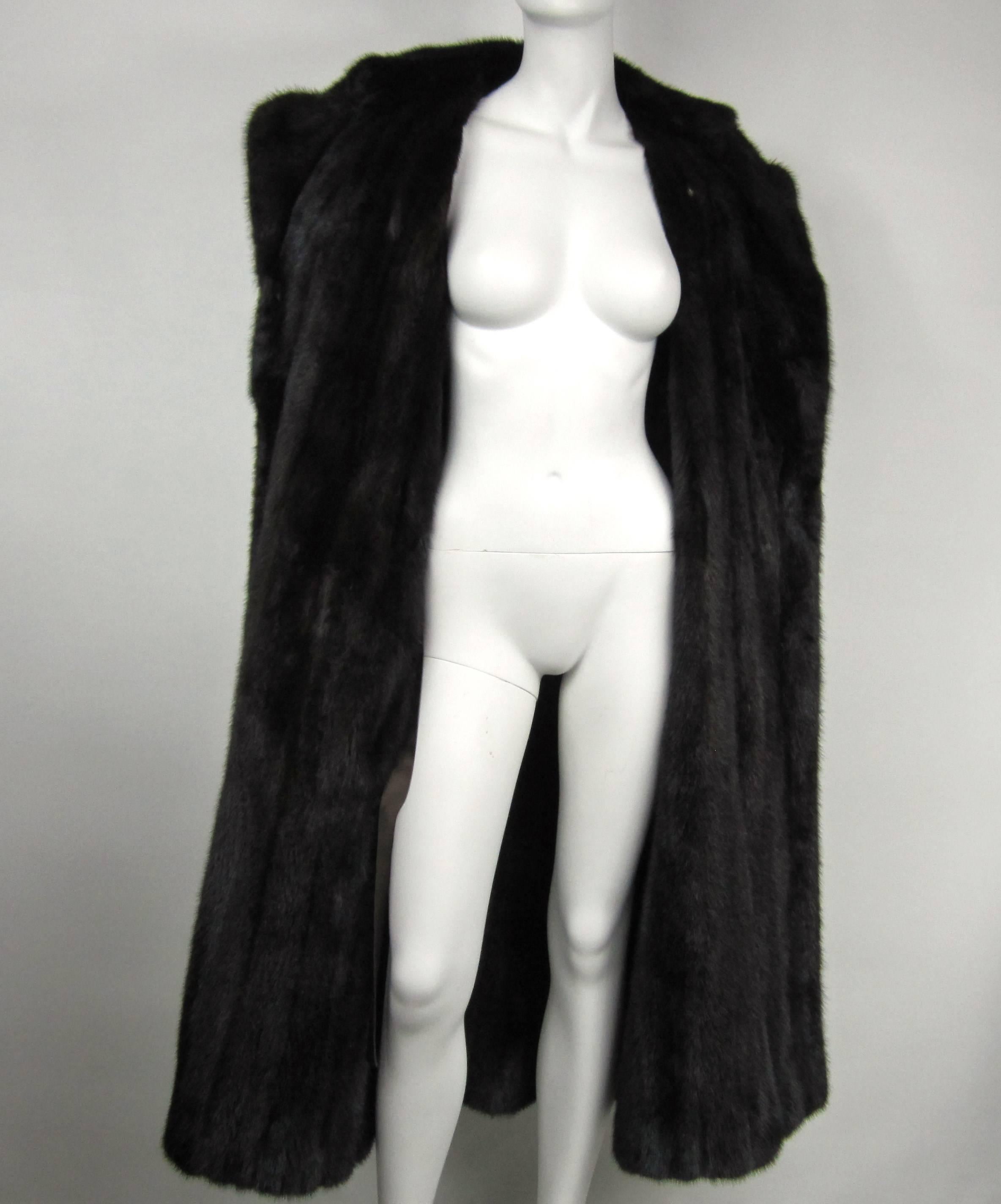 Lined inside with a dark brown mink with shoulder epaulets and Button pockets, kick pleat, 3 buttons down the front. Measuring Up to 42 in chest, Up to 40 in waist, Up to 50 in hips, 7.5 in collar, 50 inches length, 68 inch Sweep 
This will fit a