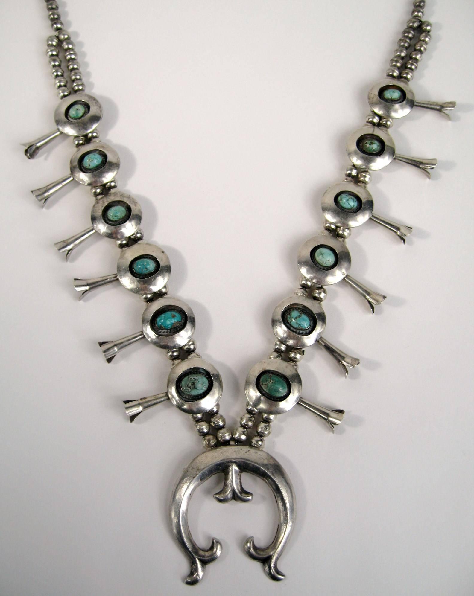 Another stunning Navajo Squash blossom Sterling silver necklace. Shadow box set turquoise stones totaling 12. Naja at the bottom measuring 2.23 inches x 2.15 inches - Blossoms are 1.79 inches long on Double beaded chain that graduates to a single